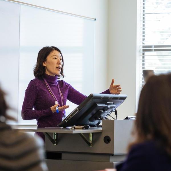 International relations studies professor lecturing at a podium.